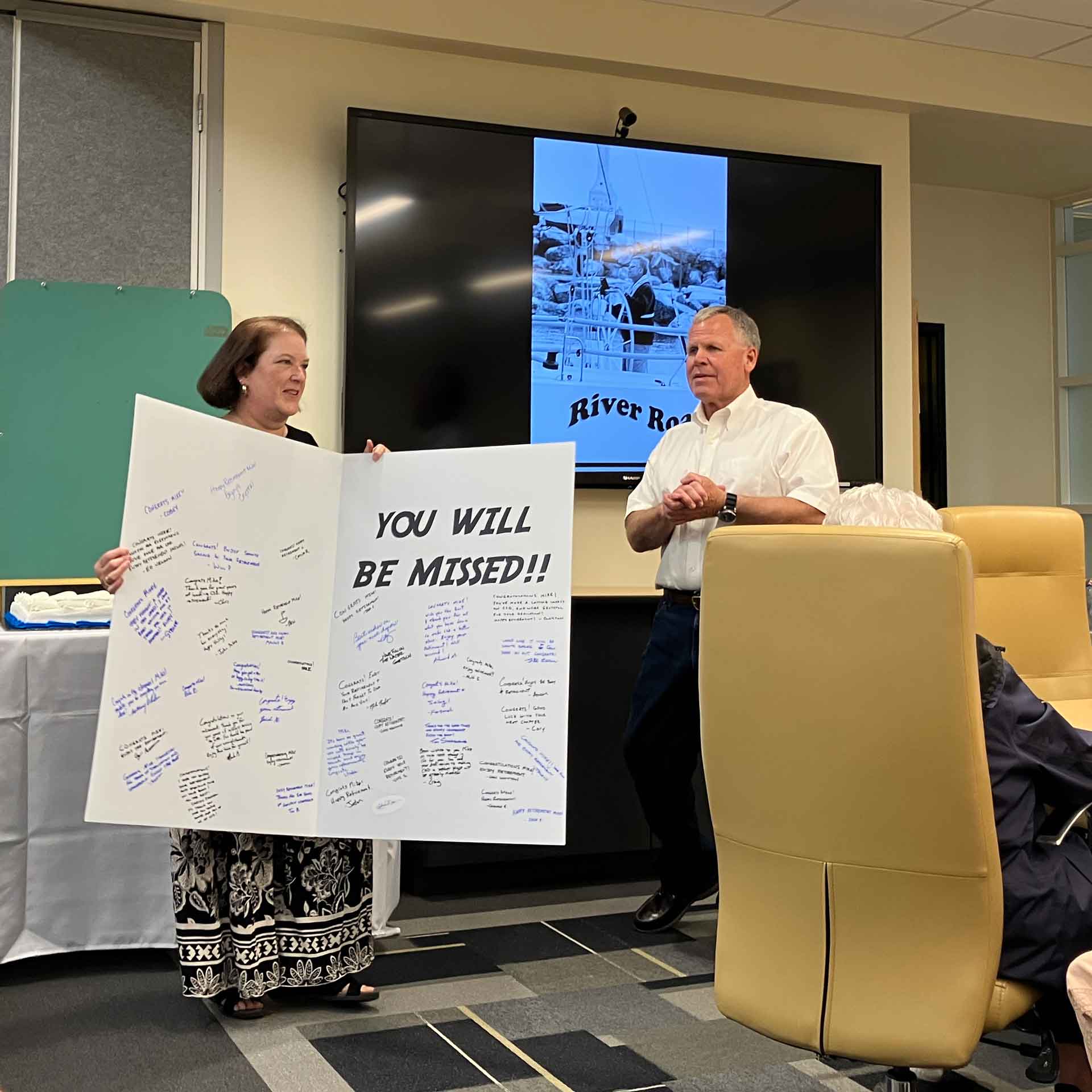Mike Ryer is presented with a card at his retirement party.